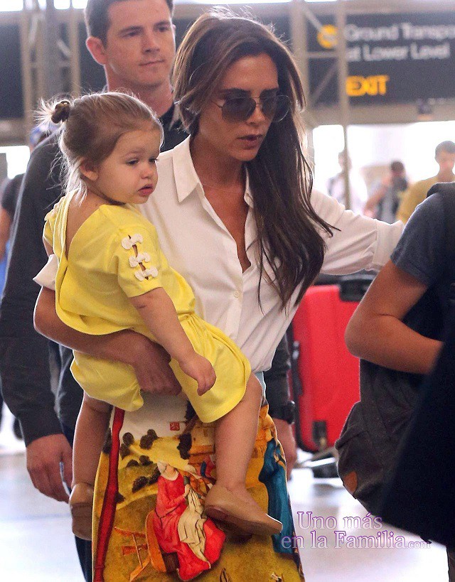 El estilo de Victoria Beckham llevando a Harper en brazos