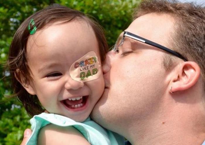 Un papá crea dibujos en el parche del ojo de su bebé