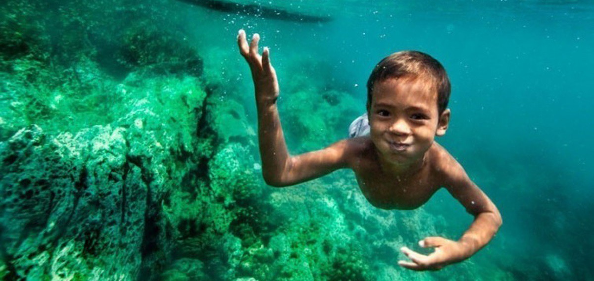 niño buceando en el mar