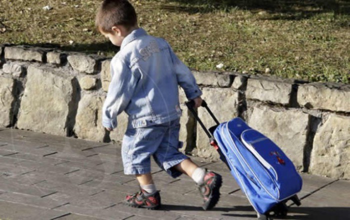 Niño al cole con mochila con ruedas