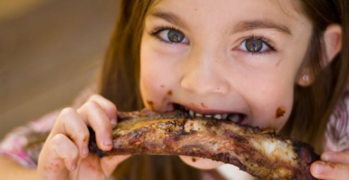 niña comiendo carne