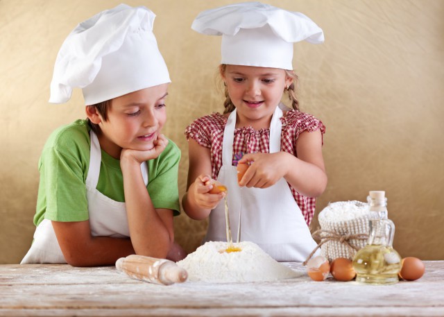 Kids preparing a cake - starting with flour and eggs
