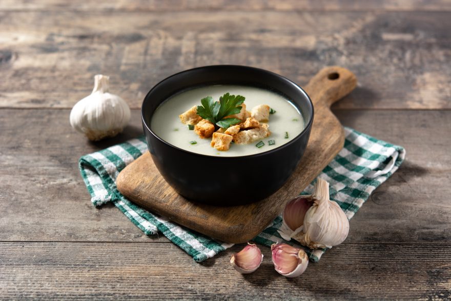Garlic Soup Topped With Croutons In Black Bowl