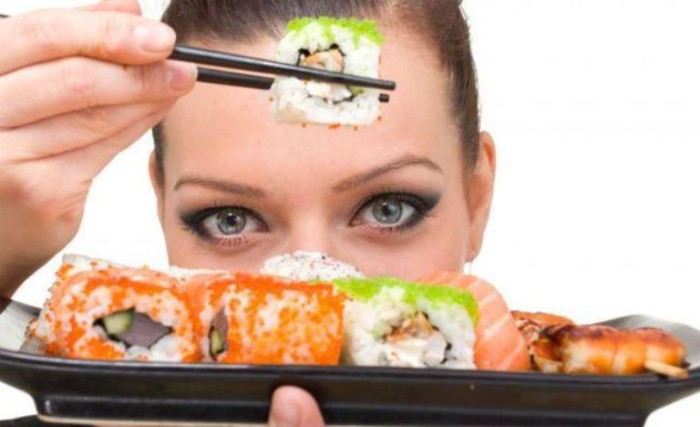 Mujer comiendo sushi